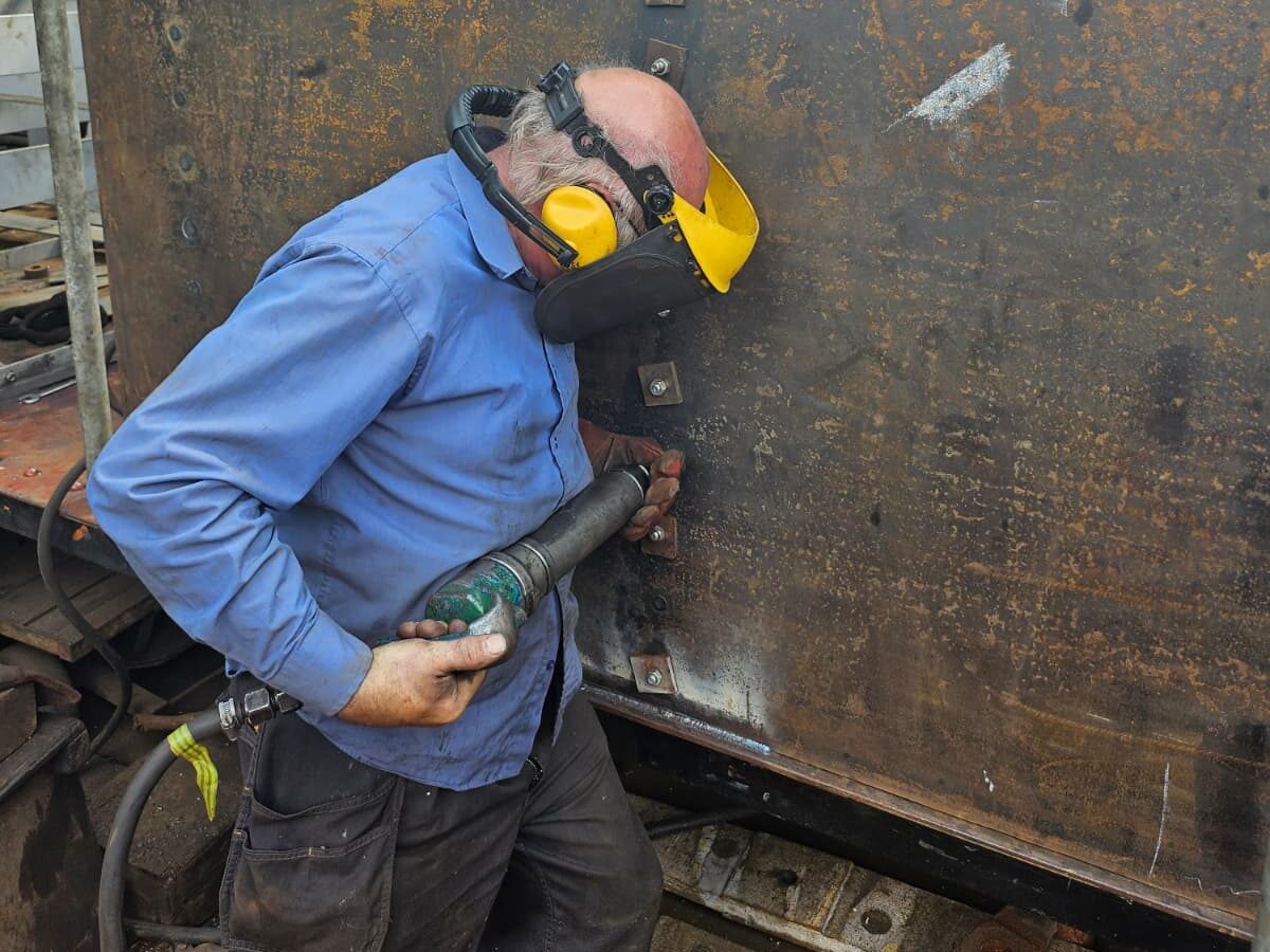 Barry Stratton riveting new side sheet for tender tank.