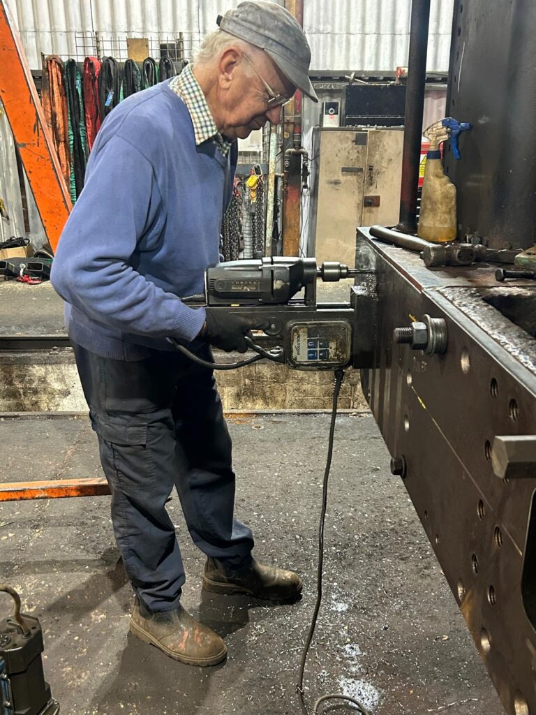 Mike on the mag drill completing the holes in the new beam while it was temporarily mounted to the chassis. 